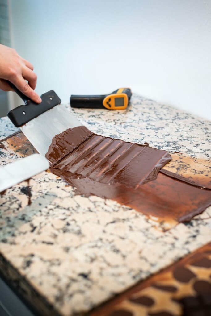 Chocolat fondu étalé à la spatule sur du marbre